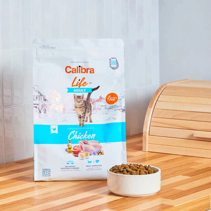 Saco de pienso Calibra Cat Life Adult Chicken para gatos adultos junto a un cuenco de croquetas
