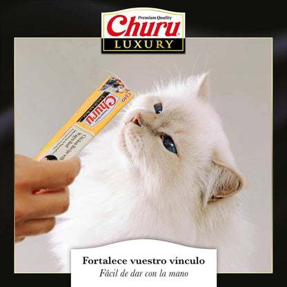 Gato blanco lamiendo un tubo Churu Luxury desde la mano; la gama incluye este puré de atún con lenguado