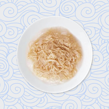 Plato blanco con caldo y tiras desmenuzadas sobre un fondo de olas azules