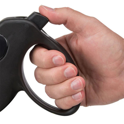 Mano sujetando la correa retráctil Ferplast mostrando el asa ergonómica y el botón de freno
