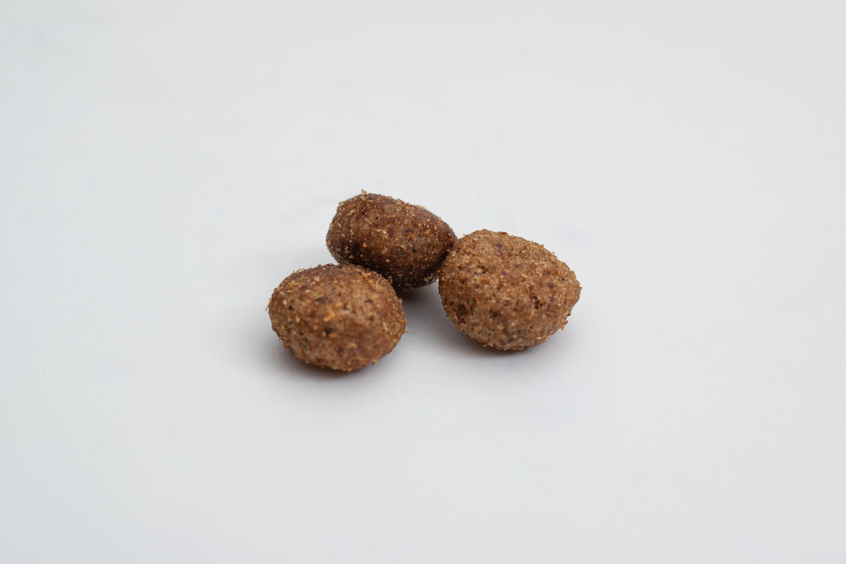 Tres croquetas pequeñas y redondas de pienso Virbac sobre fondo claro