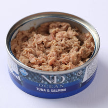 Lata abierta de esta comida húmeda atún salmón mostrando el pate desmenuzado.
