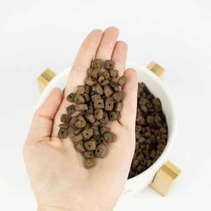 Croquetas del pienso Lenda Mini Meat and Fish en la mano
